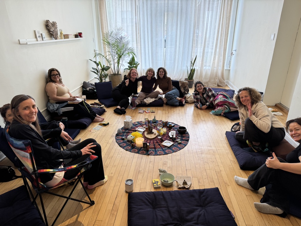 Women gathered in a circle at the studio, journaling and reflecting
