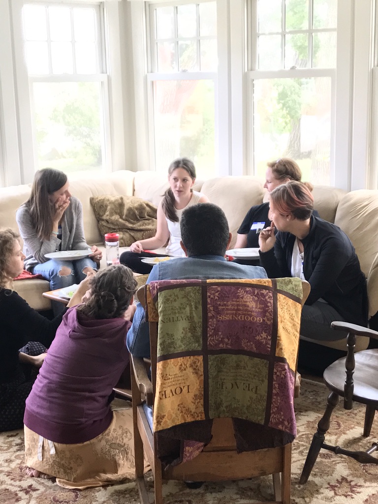 Women's circle gathered in a sunlit living room in conversation