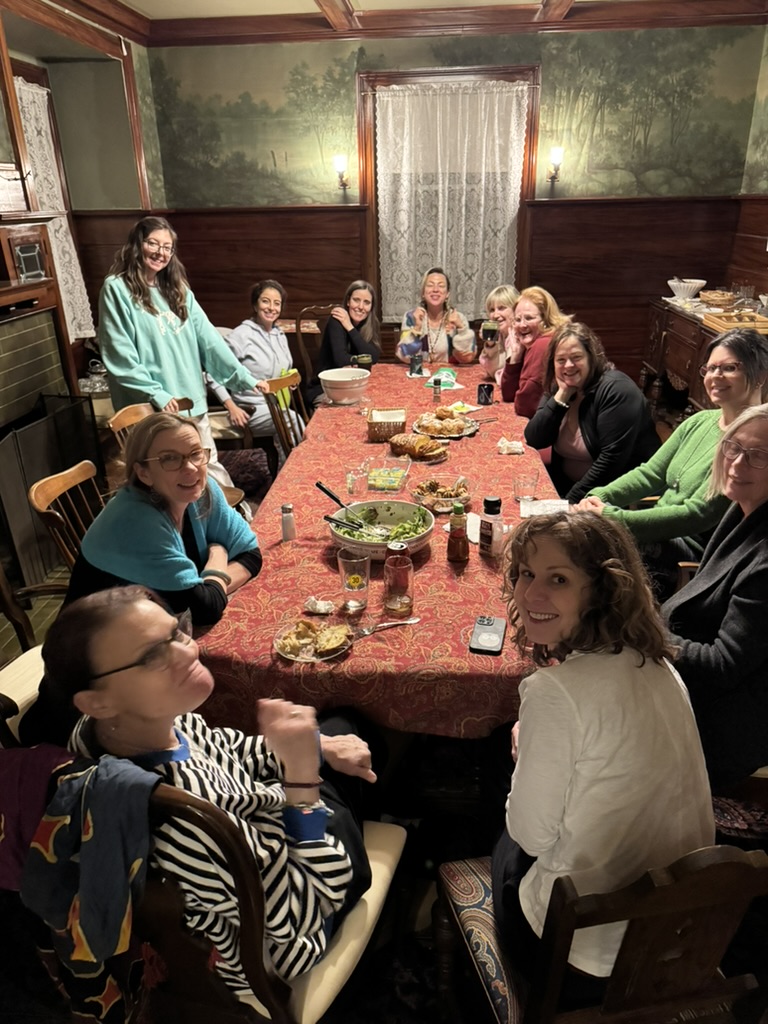 Women gathered around a dining table sharing a meal together