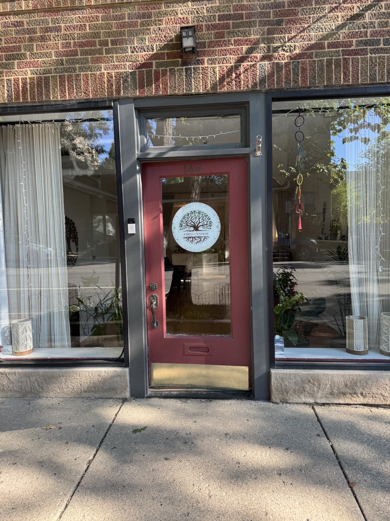 Circle Studio storefront entrance with red door and tree-of-life logo